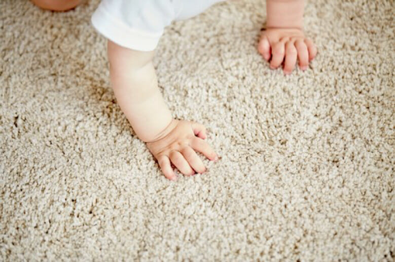 baby crawling on cream carpet